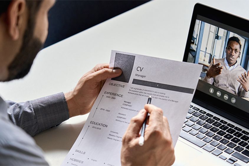 Reclutador sosteniendo un currículo en una entrevista virtual. Empleo - Banco Interamericano de Desarrollo - BID